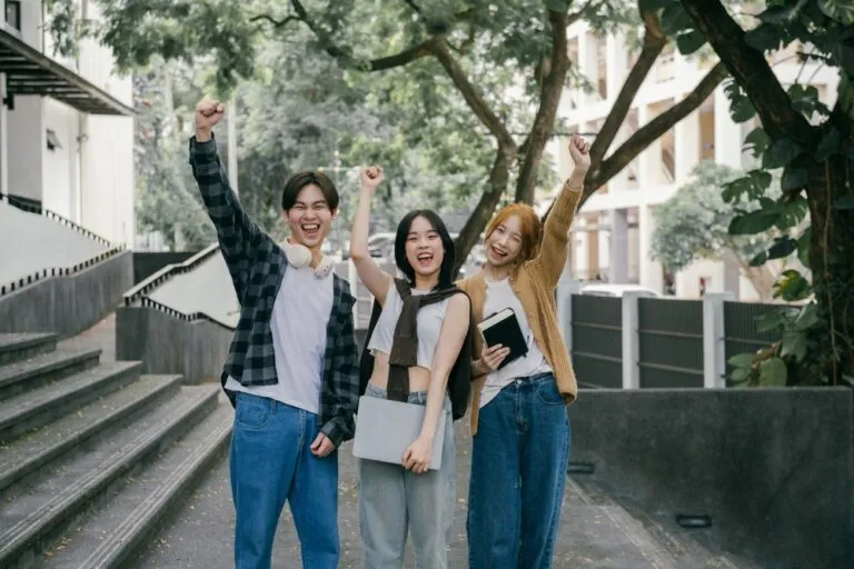 Home 2 Three,Cheerful,Asian,Students,Are,Raising,Their,Arms,In,Excitement